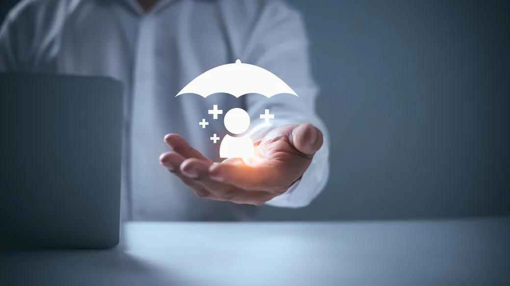 Geöffnete Hand hält ein leuchtendes Symbol einer Person unter einem Schirm.