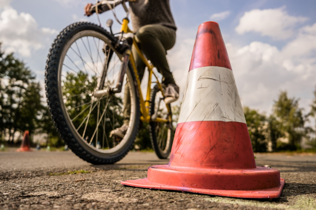 Radler umkreist einen Verkehrskegel
