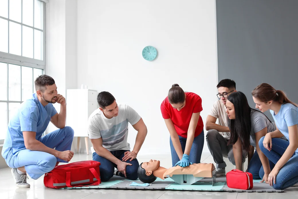 Lerngruppe bei der Herz-Druck-Massage an einer Puppe