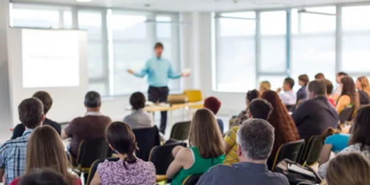 Seminargruppe sitzt vor Dozierendem