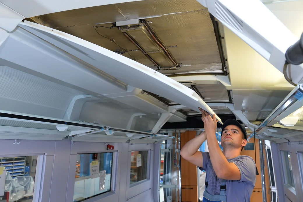 Wartungspersonal setzt eine Abdeckplatte im Wagon ein